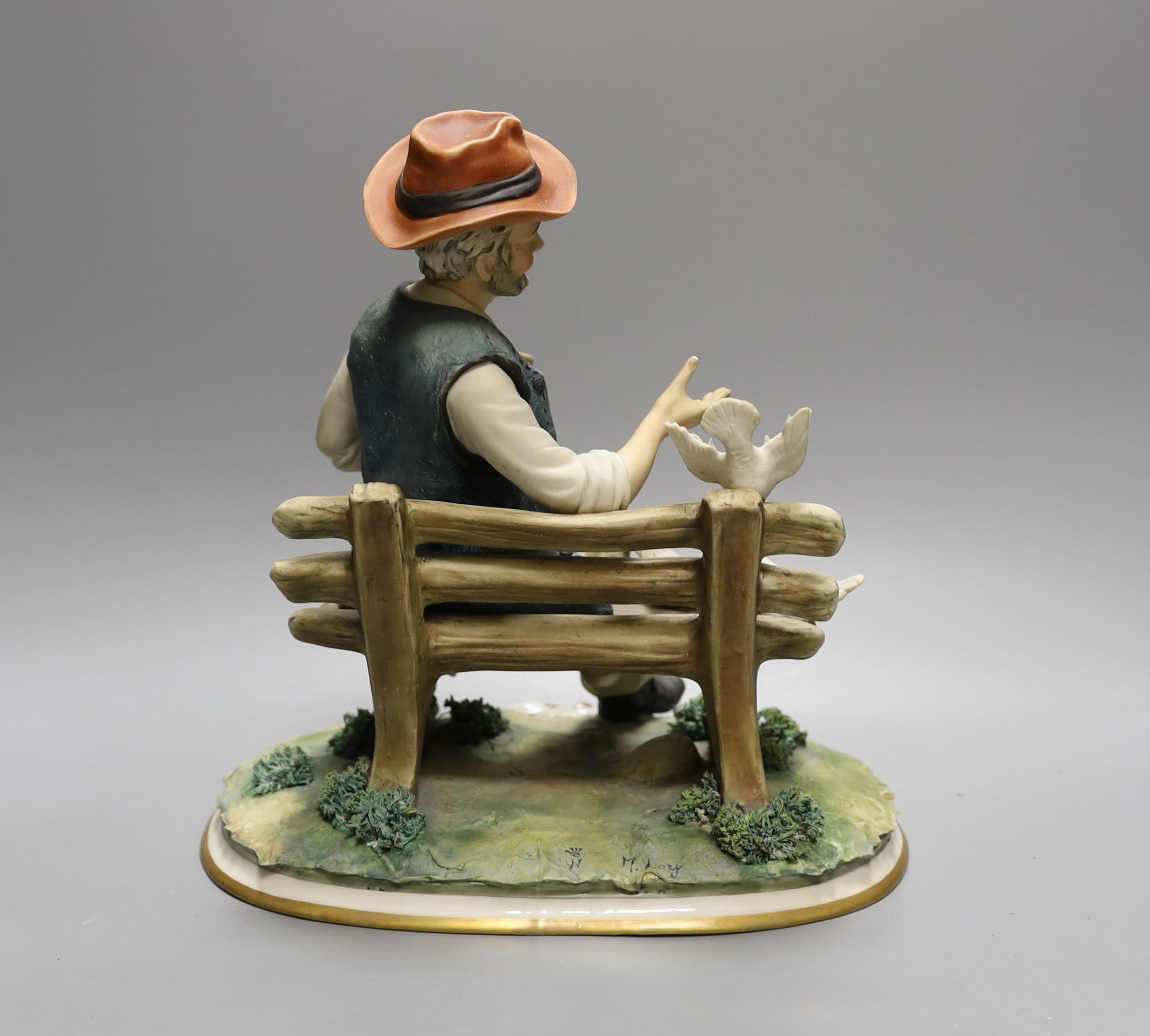 A Capodimonte figure of a tramp sat on a bench feeding doves 27cm